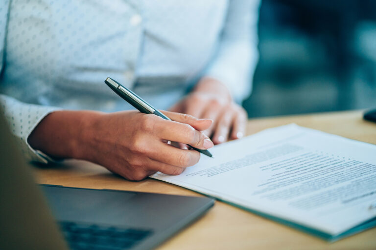 femme avec ordinateur qui signe dossier