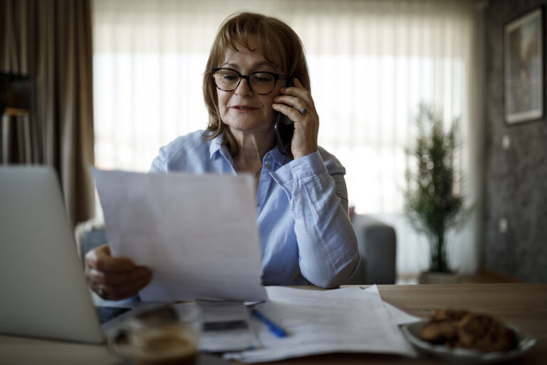 dame avec des documents au téléphone